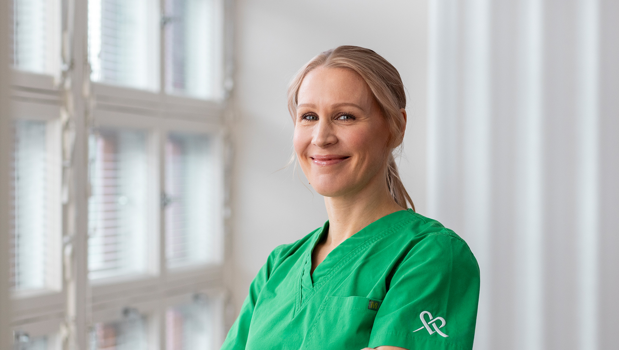 Hoitaja hymyilee ja katsoo kameraan